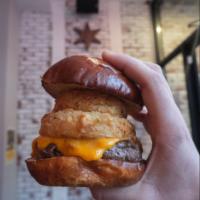 The Fifty Burger · Double Smash Burger topped with bacon, cheddar, smokey BBQ, and 2 onion rings on a pretzel b...