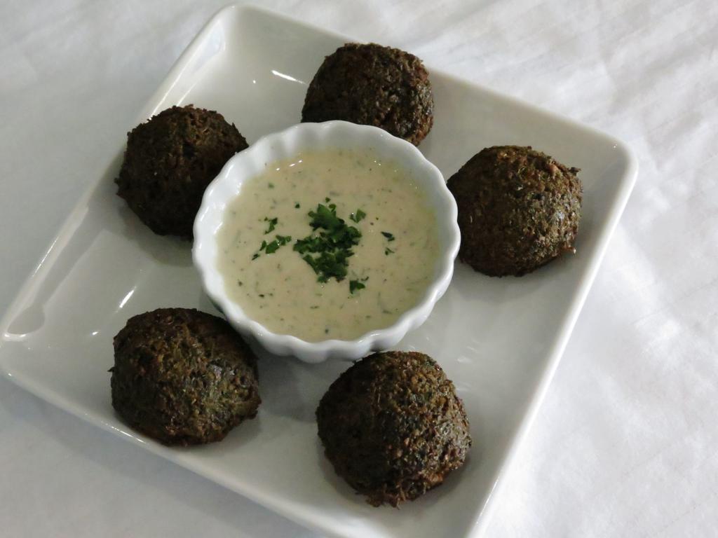 Falafel (V&GF) · 5 golden brown pieces of homemade felafel made with ground chickpeas, spices and herbs, served with tahini sauce.