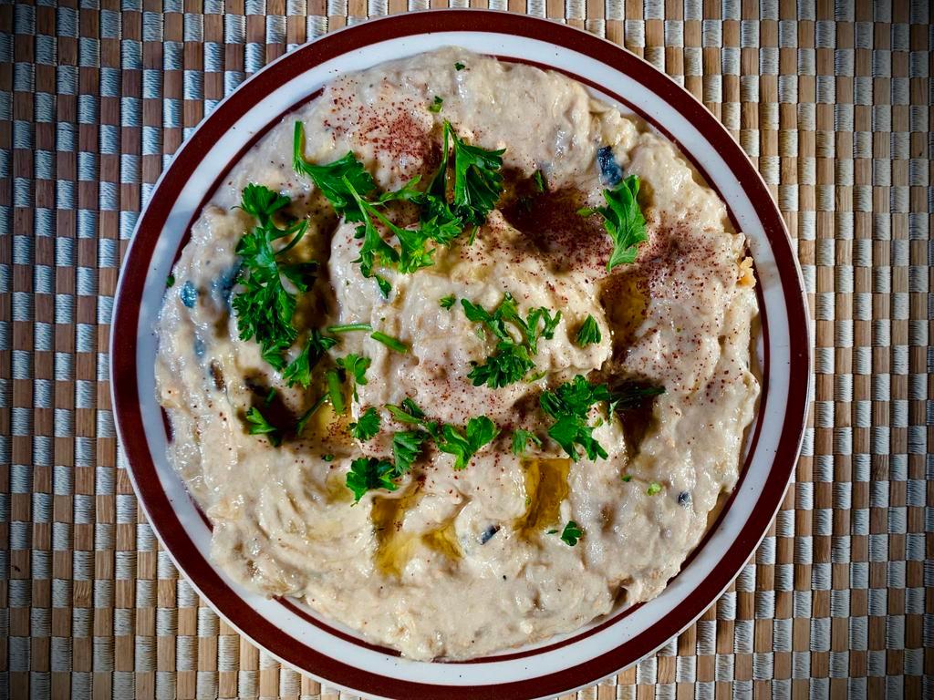Baba Ghanouj · Mashed cooked eggplant, olive oil, lemon juice, various seasonings and tahini. Serve With Pita Bread
