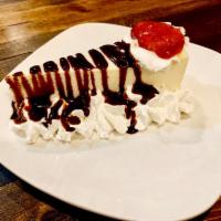 Cheesecake · Creamy classic cheesecake slice with whipping cream on the sides, a hint of strawberry sauce...