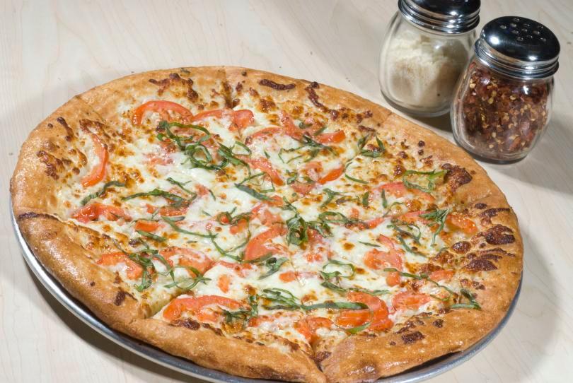 Margherita Pizza · Roma tomatoes and fresh basil with olive oil and garlic white sauce instead of marinara sauce. 