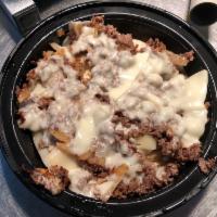 Cheesesteak Fry · Steak or chicken, onions and cheese over a bead of fries.