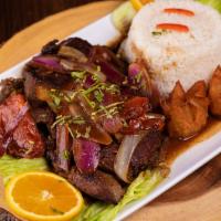 Bistek Encebollado · Tender steak marinated in a flavor-packed combination of onions and garlic sauce. Accompanie...