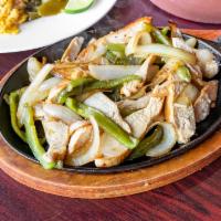 Sizzling Chicken Fajitas · Grilled chicken with green peppers and onions on a sizzle plate served with seasoned rice, l...
