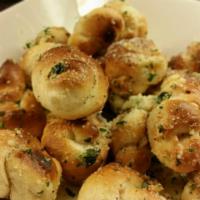Garlic Knots · 6 pieces, baked strips of pizza dough knotted and tossed in garlic, oil and parmigiana 