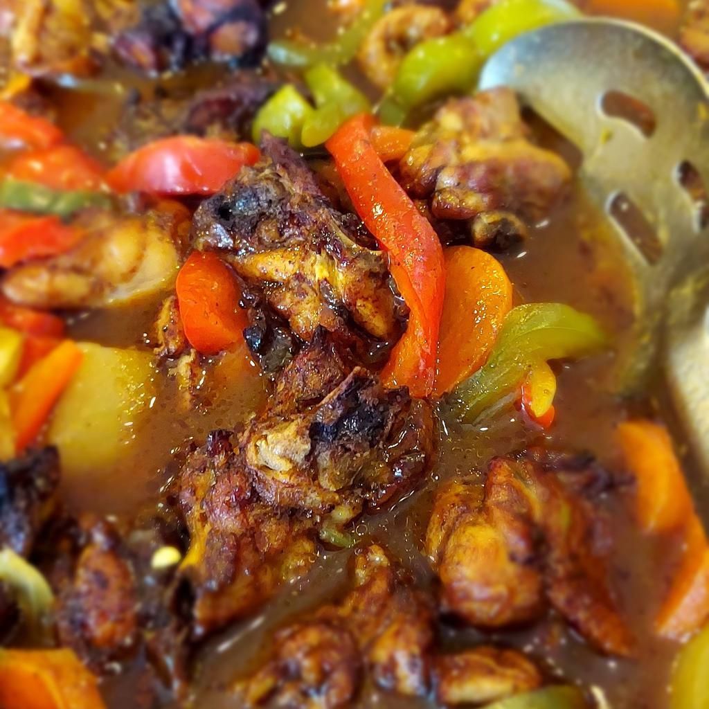 Brown Stew Chicken · Fried chunks of perfectly seasoned bone in chicken simmered in a delicious brown gravy with peppers, onions, potatoes and carrots