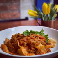 Pappardelle alla Bolognese · Flat ribbon pasta (made with eggs) cut in house just for our famous Bolognese sauce. Vegan S...