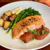 Grilled Salmon Filet · served medium rare with oven roasted tomatoes and broccoli rabe.