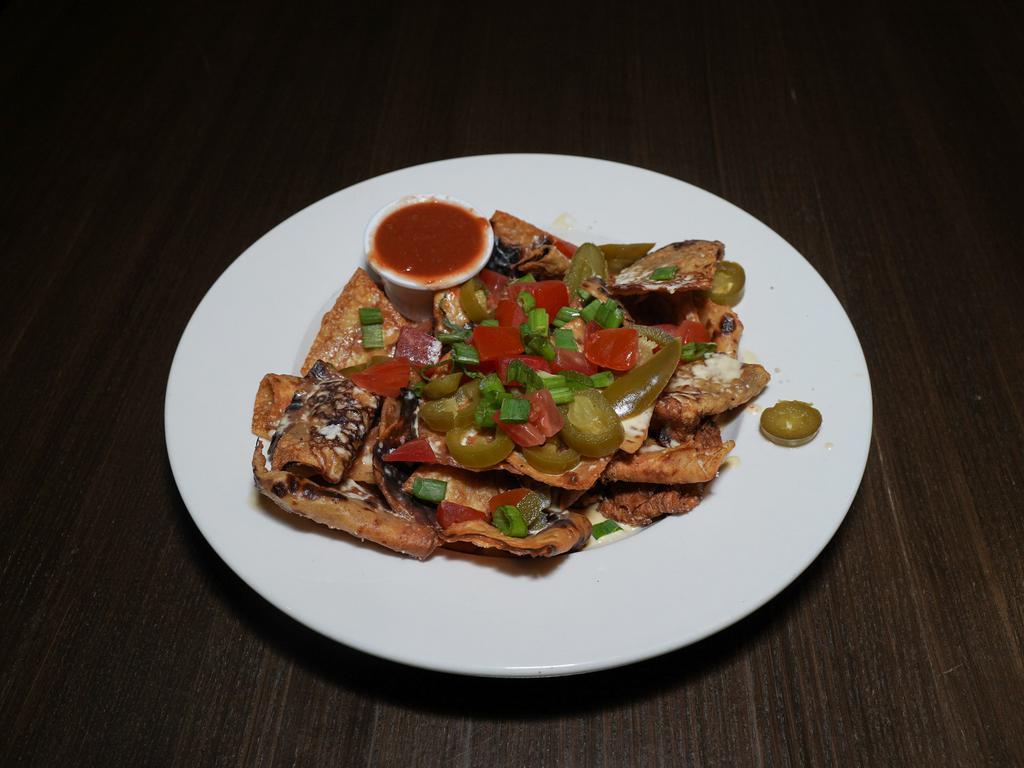 Irish Nachos · House-made boxty chips smothered in our creamy 3-cheese sauce and topped with scallions, tomatoes, jalapenos, sour cream. Salsa served on the side.