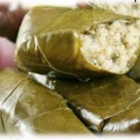 Dolmades · Grape leaves stuffed with blend of herbs, spices and rice, soaked in a lemon sauce (5 pieces...