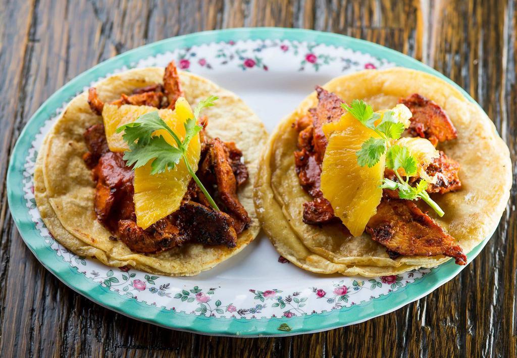 Al Pastor de Pollo Tacos · Spit roasted chicken marinated in chile guajillo, charred pineapple and cilantro. Gluten free.