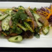 Yum Neau · Sliced grilled steak seasoned with lime juice, cilantro, red onions, scallions, chili, tomat...