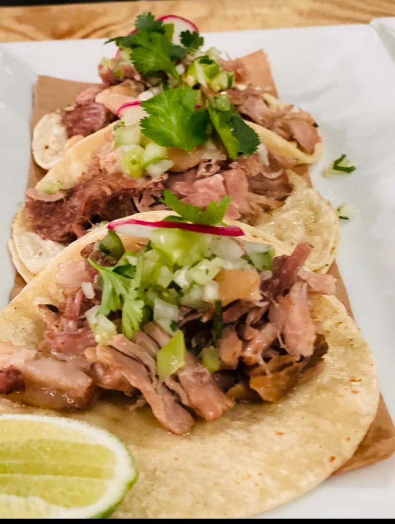 Tacos de Carnitas · Slow braised pork, tomatillo pico de gallo, crispy pork skin.
