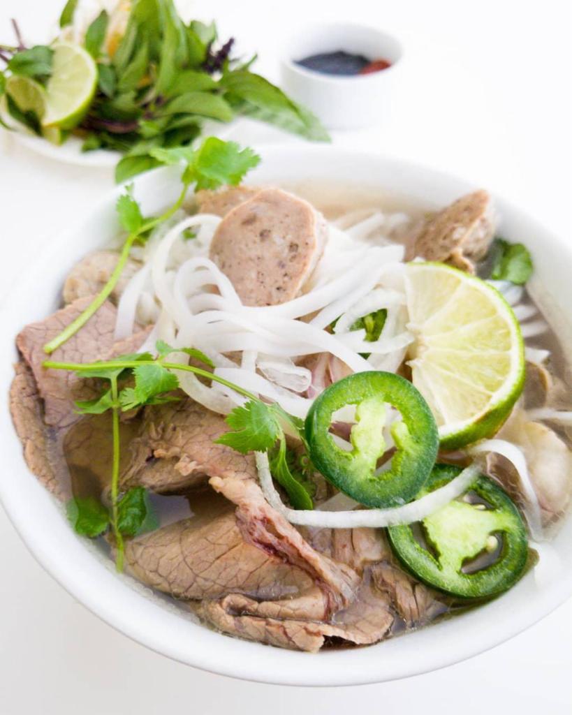 #9. Pho Tai, Bo Vien · Eye of round steak and meatballs. Eye of round steak, beef meatballs with noodle and beef broth. Topped with white onion, green scallion and cilantro. Served with side of beansprout, Thai basil, jalapeno sliced and wedge of lime.
