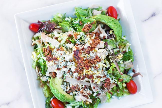 Turkey Cobb Salad · Sliced Turkey, romaine & spring mix lettuce with avocado, grape tomatoes, chopped bacon, crumbled blue cheese, boiled egg & Red Wine Vinaigrette