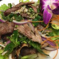 Yum Grilled Pork Salad · Grilled tender pork mixed in spicy lime juice with red onion, lemongrass, tomato, cilantro, ...