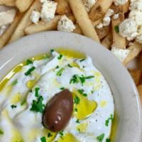Feta Fries with Tzatziki · Tsatsiki lightly drizzled with Greek olive oil and Kalamata olive, alongside fries topped wi...