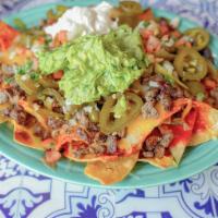 Crispy Nachos · Layers of tortilla chips topped with sauce, cheese, beans, jalapenos, pico de gallo, sour cr...