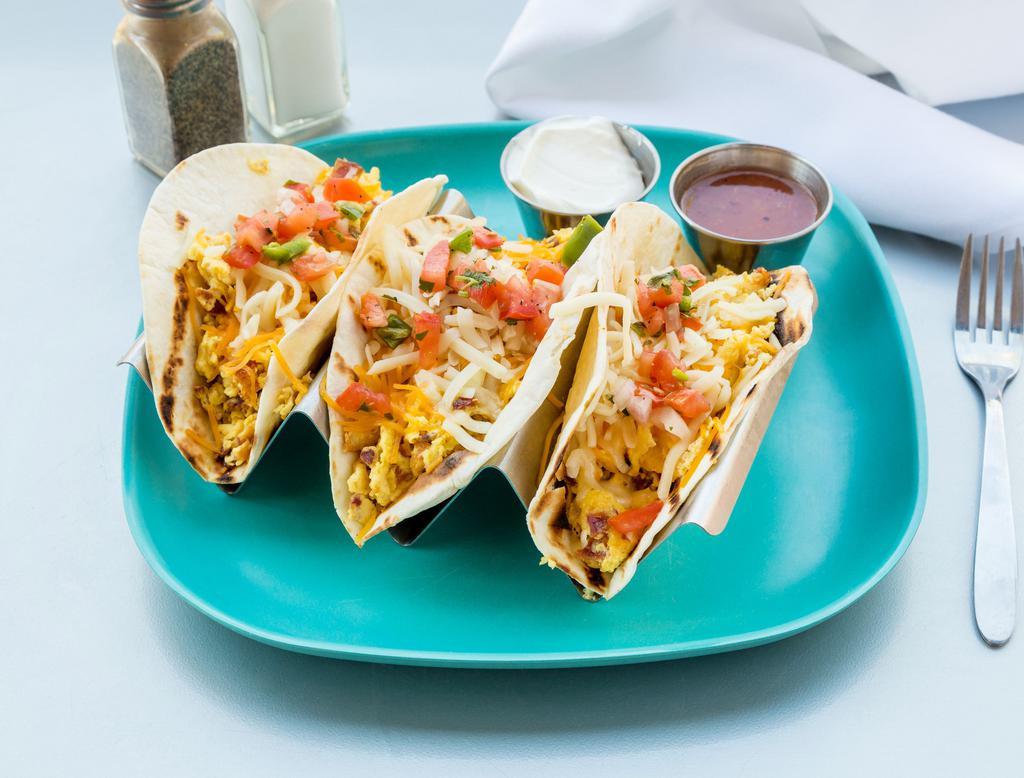 Breakfast Tacos · 3 corn tortillas filled with scrambled eggs topped with jack cheese, salsa, sour cream and a choice of meat. Choice of side.