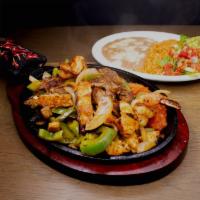 Trio Fajitas · Grilled steak, chicken, and shrimp cooked with onion, peppers, and tomato, served with guaca...