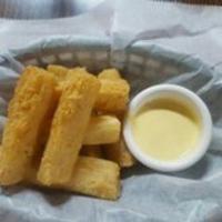 Yucas a la Huancaina · Fried yuca with delicious cheese yellowpepper sauce and creole red onions.