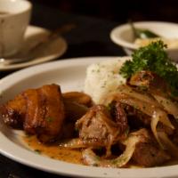 Masitas de Puerco · Morsels of pork marinated Cuban style topped with sauteed onions. Served with jasmine rice, ...