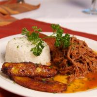 Ropa Vieja · Marinated Cuban style shredded flank steak in a tomato sauce with raisins and green olives. ...