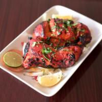 21. Tandoori Chicken · Chicken marinated in red masala sauce and aromatic spices cooked in clay oven. Served with r...