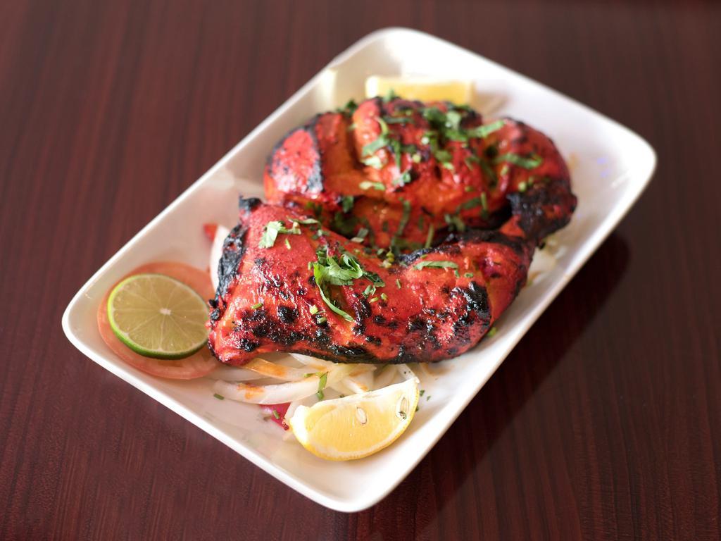 21. Tandoori Chicken · Chicken marinated in red masala sauce and aromatic spices cooked in clay oven. Served with rice and peas.