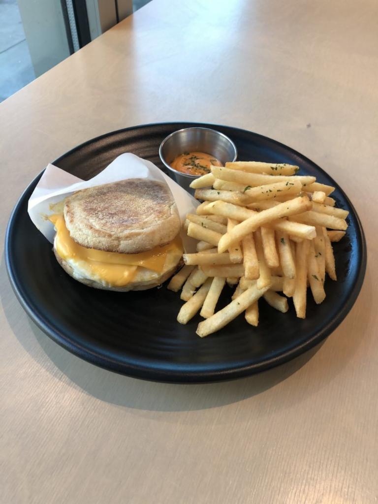 Egg And Cheese Sandwich · English Muffin, Egg, Cheese Butter, Served with Fries  
(Add Sriracha Bacon, Chicken Apple Sausage or Grilled Chicken  +$2)