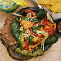 Classic Molcajete · A hot stone bowl filled with ribeye steak, chicken, shrimp, poblano peppers, onions, chunks ...