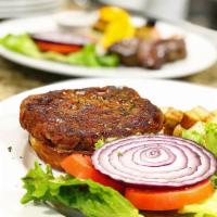 Veggie Burger · Veggie burger garnished with tomato, red onions and lettuce.