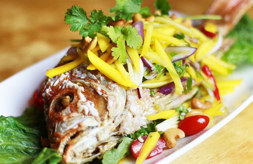 SP1. Branzino Mango Salad · Battered and deep fried Branzino topped with mango salad, red onions, cashew nuts, scallions, tomatoes with lime-chili dressing. Spicy. Served with jasmine rice. 