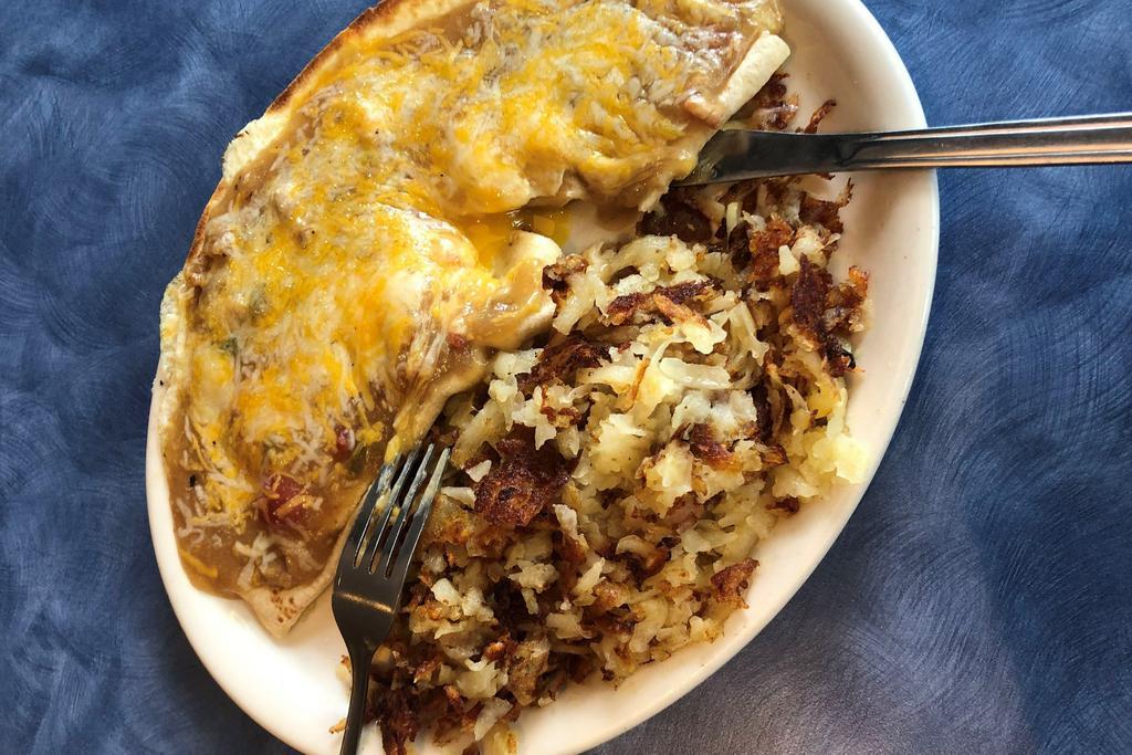 *Huevos Rancheros* · two eggs any style wrapped in a flour tortilla and smothered with pork green chili, topped with cheddar cheese and served with hash browns