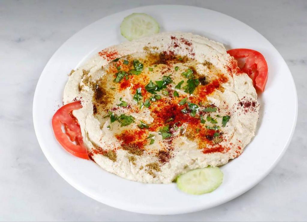 Hummus · A delightful dip of garbanzo beans, tahini, garlic, lemon juice, and olive oil. Served with pita bread.