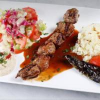 Lamb Shish Kebab Plate · Charcoal grilled skewered lamb cubes. Served with rice, salad, pita bread, and hummus.