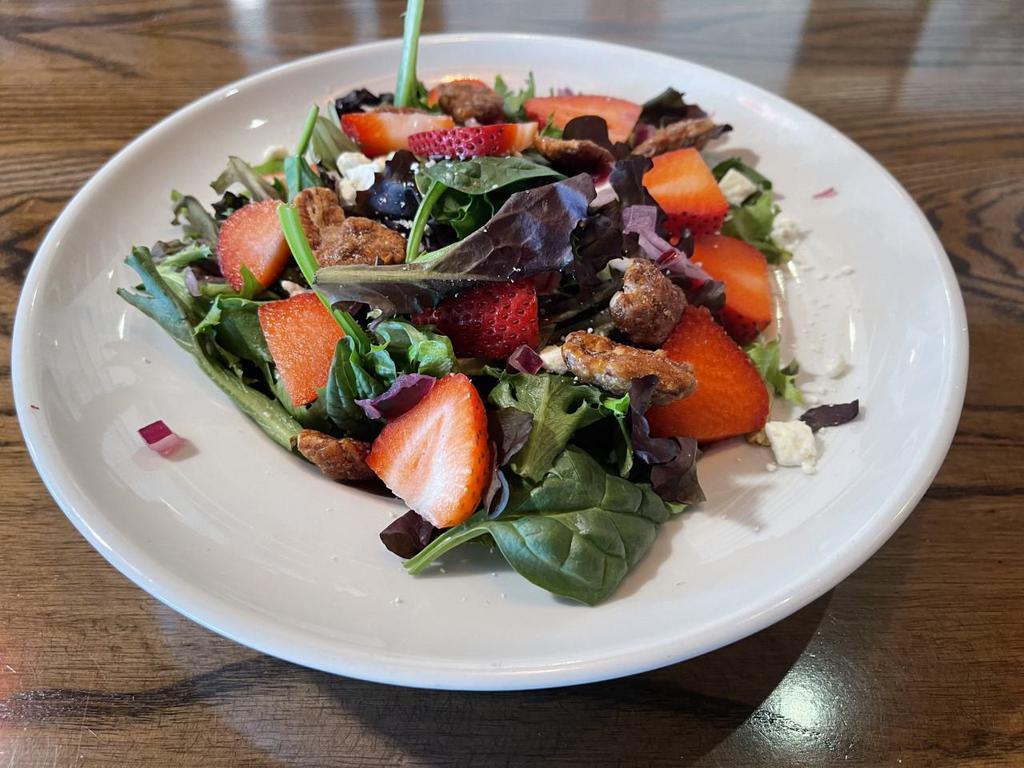 Strawberry Fields Salad · Baby spinach and arugula, red onions, strawberries, candied walnuts, feta and red onions with poppy seed dressing. Add chicken for an additional charge.