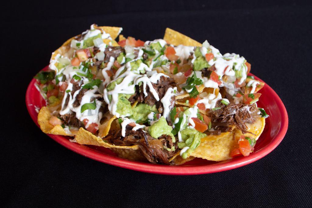 Mini Nachos · Choice of meat, chips and cheese topped with guacamole, sour cream and pico.