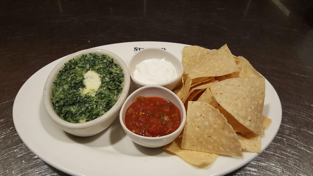 Spinach and Artichoke Dip · Fresh spinach, artichoke hearts, and onions, blended with Monterey Jack tossed in a Parmesan cheese sauce. Served with fresh tortilla chips.