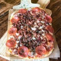 Butcher Pizza · Tomato sauce, mozzarella, shaved ribeye, pepperoni & bacon.