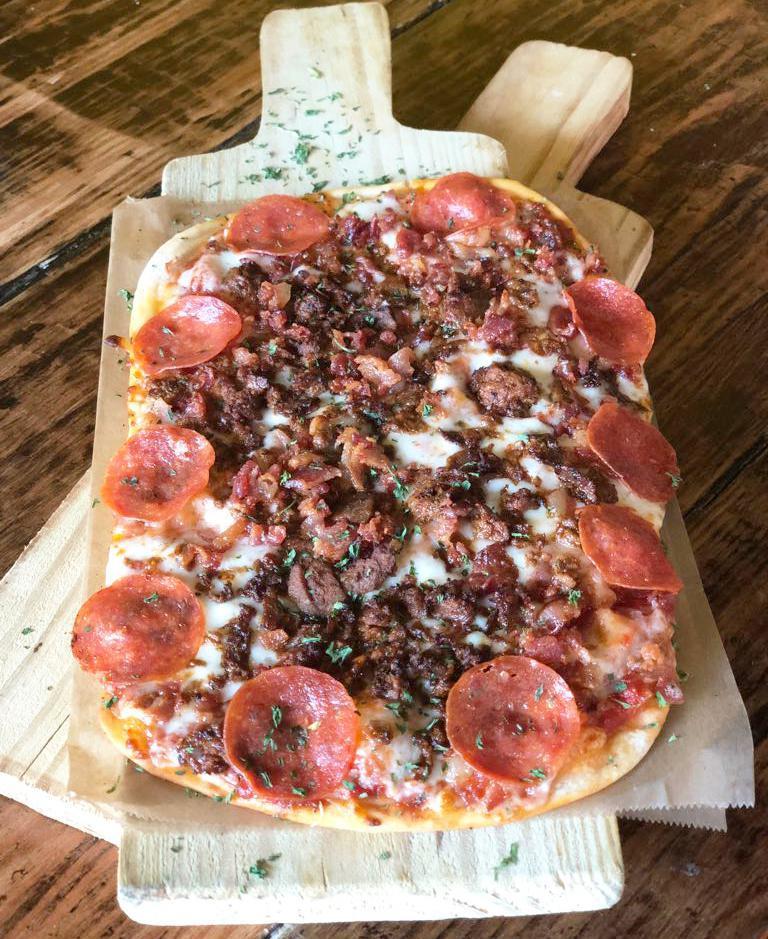 Butcher Pizza · Tomato sauce, mozzarella, shaved ribeye, pepperoni & bacon.
