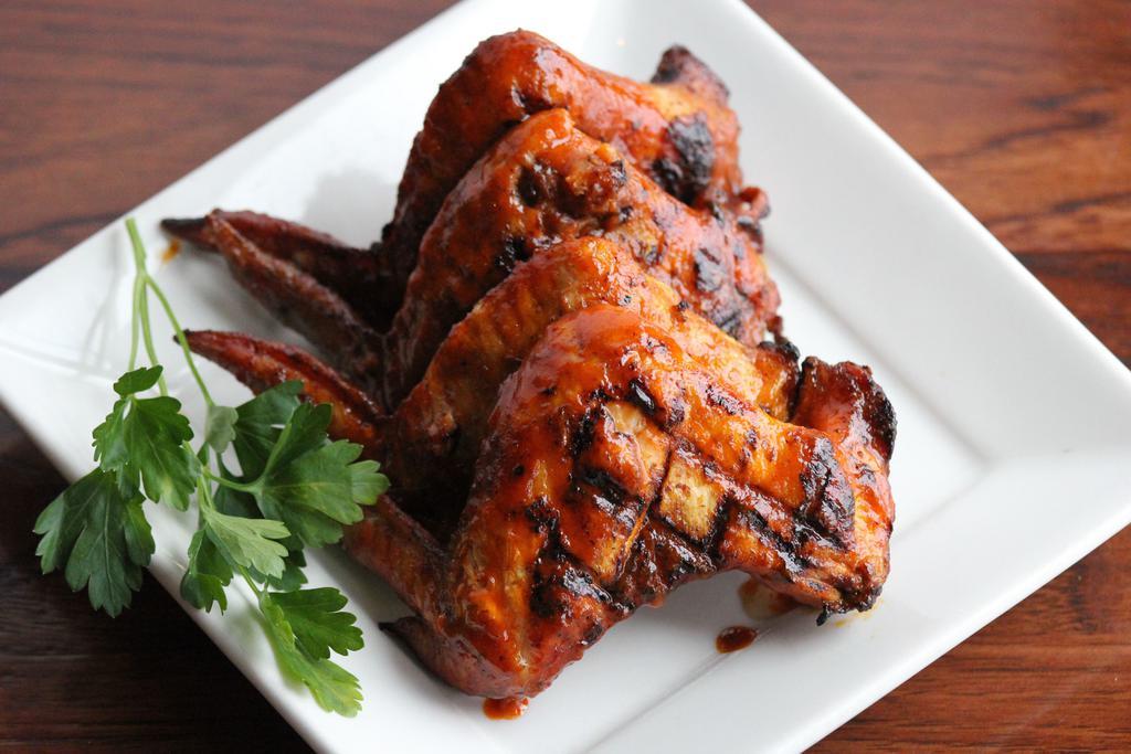 Rotisserie Buffalo Wings · Six whole wings rubbed with signature herbs and spices, roasted over an open flame and brushed with our honey buffalo sauce.  Served with ranch or blue cheese dressing. GF