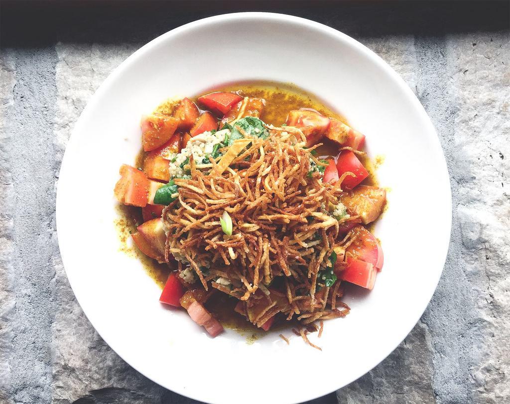 Toasted Quinoa Chicken Salad · A tower of quinoa, cucumber, bell pepper, rotisserie chicken, corn, arugula, scallion, mint, basil, lime, and crispy shoestring potatoes and roma tomatoes with curry vinaigrette on the side.