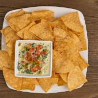Spinach Artichoke Dip · Creamy spinach, tender artichokes, mozzarella and Parmesan cheeses served with chips.