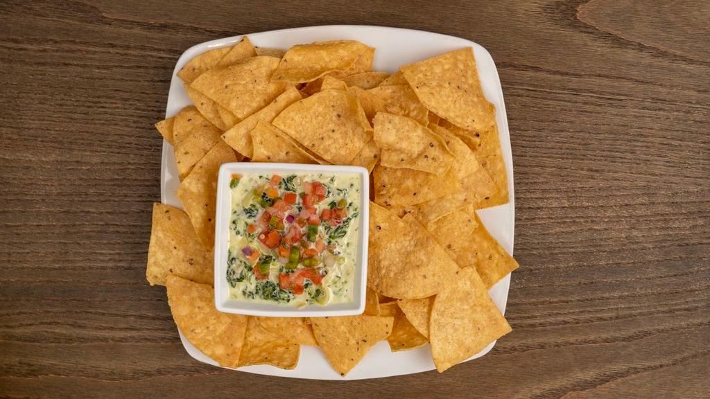 Spinach Artichoke Dip · Creamy spinach, tender artichokes, mozzarella and Parmesan cheeses served with chips.