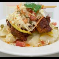 Chancho con Yuca · Chunks of marinated fried pork served with boiled cassava and fresh cabbage salad.