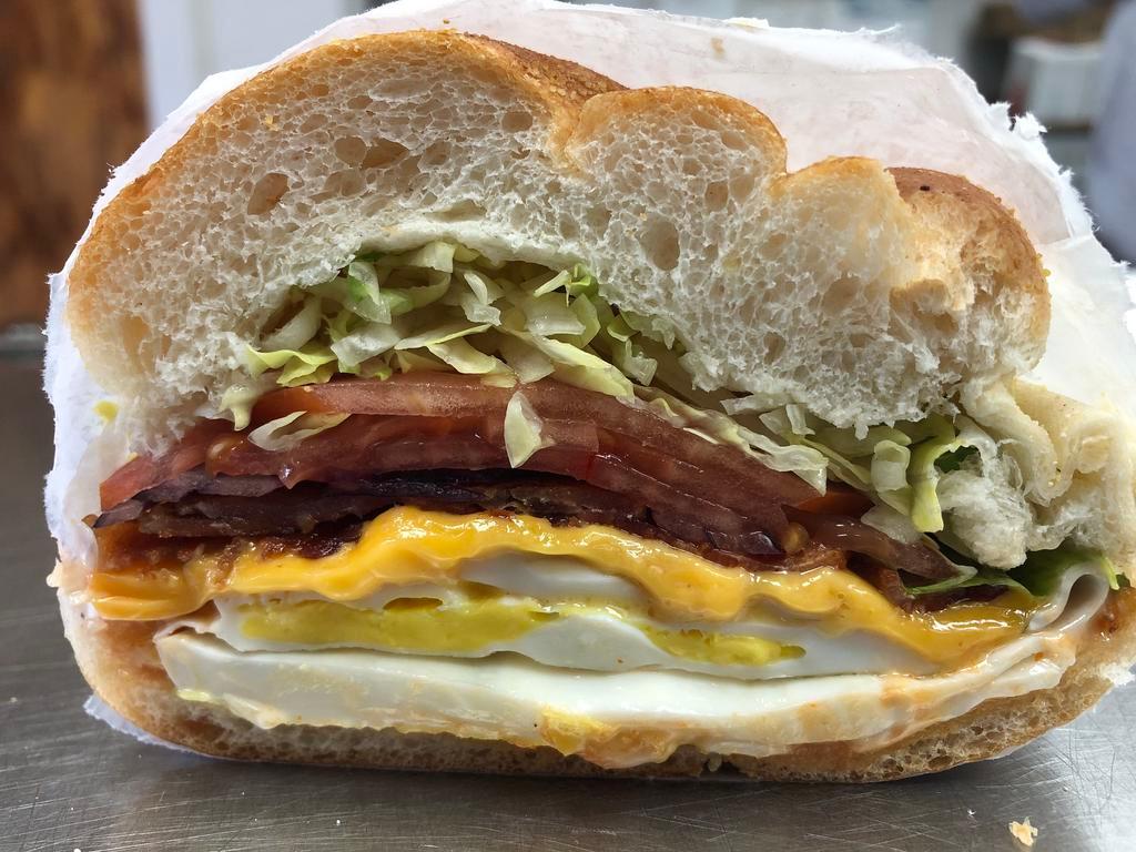 2. El Grammero Specialty Breakfast Sandwich · 2 eggs scrambled, bacon, cheese, lettuce, tomato, onion, ketchup, mayo, and hot sauce on a roll.