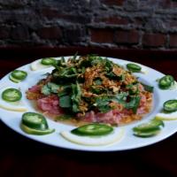 62. Marinated Raw Beef in Lemon  · Bo tai chanh. Thin slice of tender raw steak marinated in lemon juice. Topped with peanut, f...