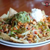 Nachos Grande · Crispy tortilla chips smothered with chili and melted cheddar Jack cheese. Topped with sour ...