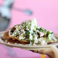 Pinche Tostada · Corn tortilla topped with beans, guacamole, queso fresco, sour cream, onions, cilantro and s...